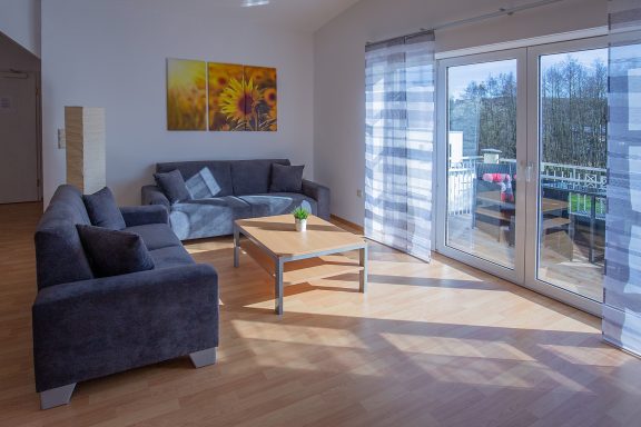 Wohnbereich Moderne Wohnzimmereinrichtung mit Sofa, Tisch und Fenster, Blick nach draußen.