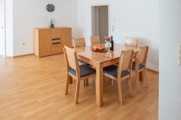 Essbereich Heller Essbereich mit Holztisch, sechs Stühlen und Obstschale.